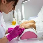 Maniucre met roze handschoentjes aan het werk